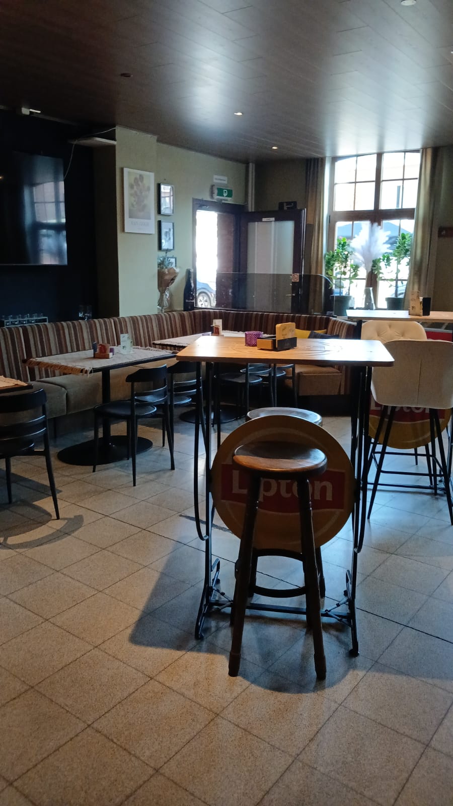 Zithoek met bank, hoge tafels en zicht op het terras