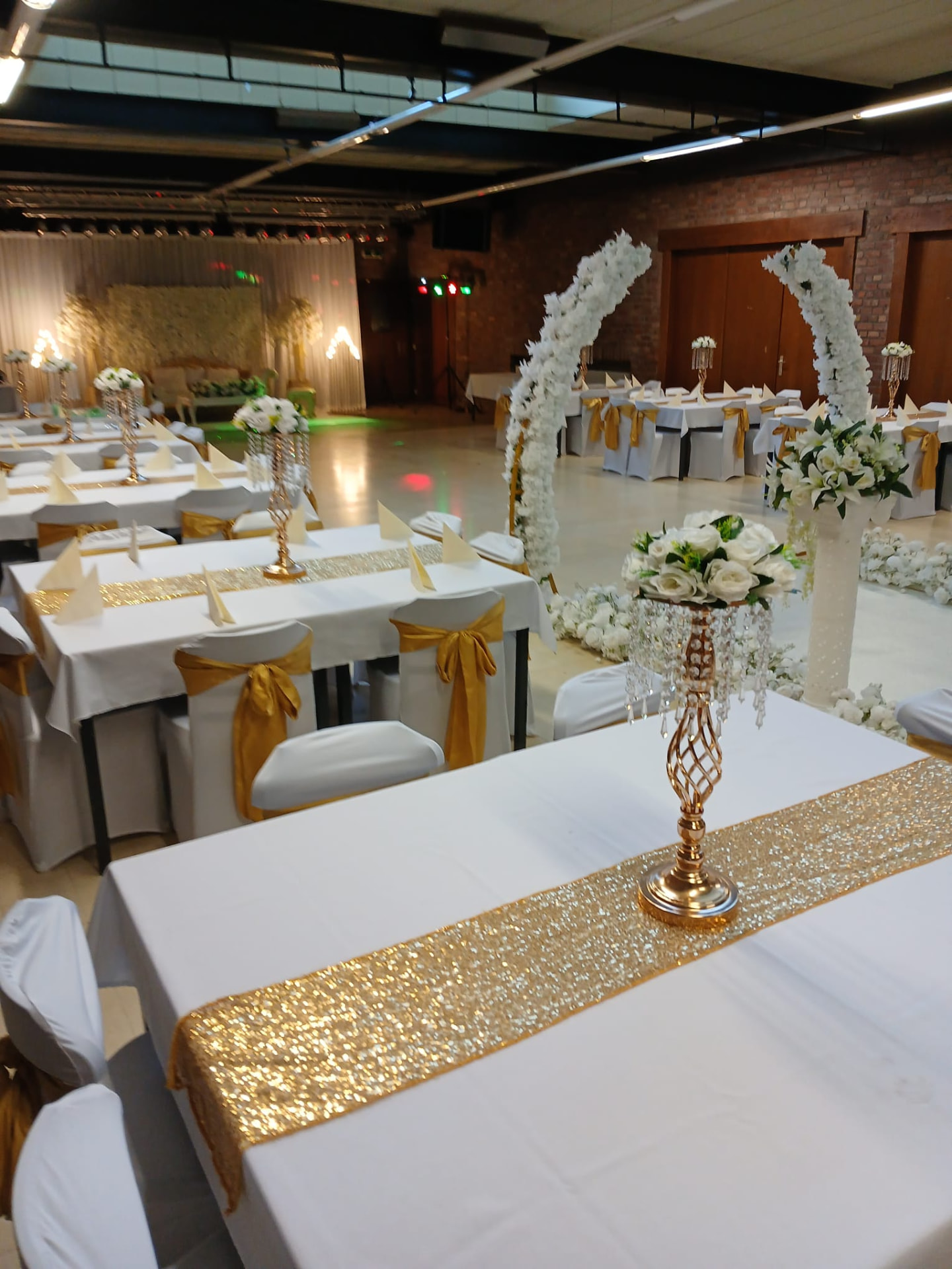 Feestzaal van D'Olmse Mét ingericht met witte tafels en gouden decoratie